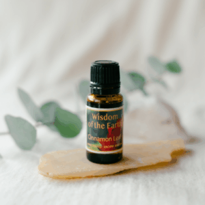 精油ボトルが、ユーカリの葉と石の上に置かれている写真